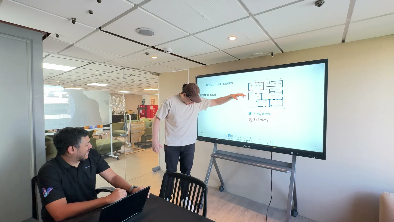 A presenter walking a colleague through a project plan on Veld Board in a meeting room