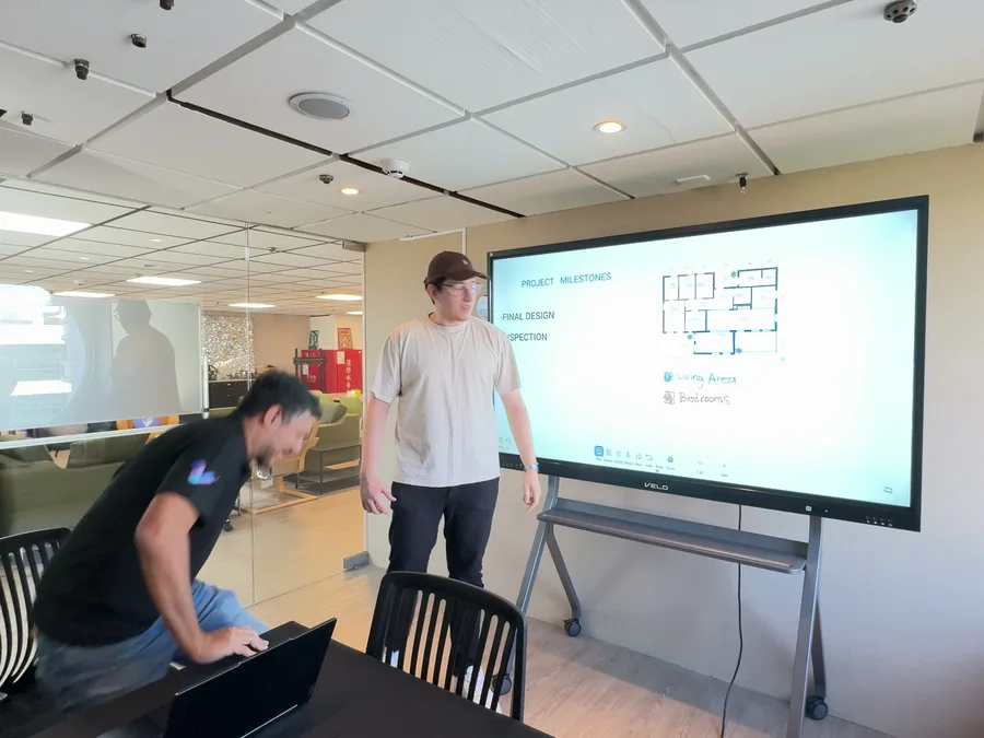 Two people discussing a plan on Veld Board in a meeting room